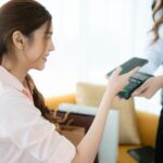 Cropped shot of woman paying with credit card in the shop's VIP lounge